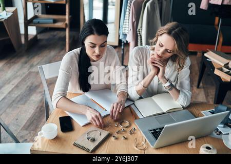 Que choisir ? Vue de dessus de belles jeunes femmes choisissant des bijoux tout en étant assis dans l'atelier Banque D'Images