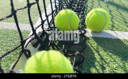 Balle de tennis jaune et verdâtre vif sur un court fraîchement peint Banque D'Images