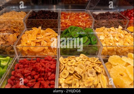 Un affichage vibrant de divers fruits et légumes séchés disposés soigneusement dans des récipients transparents. Banque D'Images