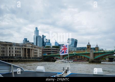 Promenade en bateau sur la Tamise en direction du pont Southwark. Drapeau de la Grande-Bretagne agitant. Drapeau du Royaume-Uni dans le vent. Tourisme à Londres. En déplacement Banque D'Images