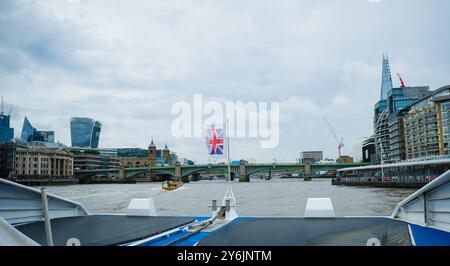 Promenade en bateau sur la Tamise en direction du pont Southwark. Drapeau de la Grande-Bretagne agitant. Drapeau du Royaume-Uni dans le vent. Tourisme à Londres. En déplacement Banque D'Images