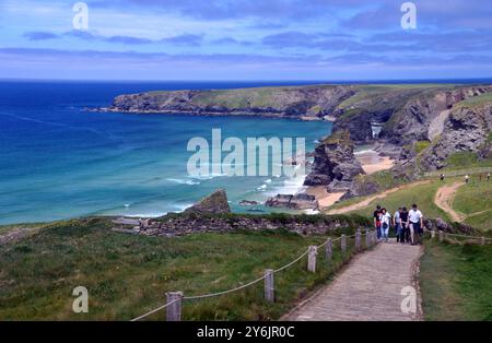 Touristes / vacanciers marchant sur le chemin vers Carnewas point de Bedruthan Steps (Sea Stacks) sur le sentier côtier du Sud-Ouest, Cornouailles du Nord, Angleterre, Royaume-Uni. Banque D'Images