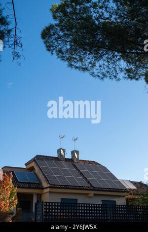 détail du toit d'une maison individuelle avec cheminées et panneaux solaires photovoltaïques pour une énergie alternative et durable sur le toit. C'est l'automne Banque D'Images