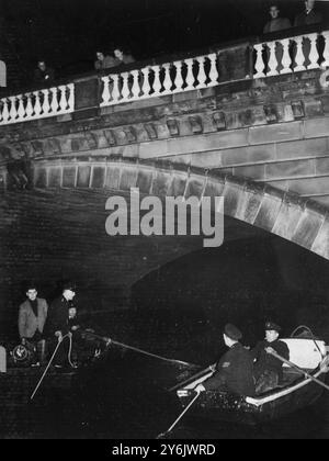 Chasse à la pierre du couronnement volée à l'abbaye de Westminster le jour de Noël . Spectateurs sur le pont Serpentine regardant la police traîner dans deux bateaux à rames ci-dessous. 28 décembre 1950 Banque D'Images