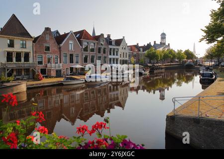 Reflets de maisons traditionnelles, barges et bateaux sur le petit canal (klein Diep) à Dokkum, Frise, pays-Bas, avec le Oud Stadhuis Banque D'Images