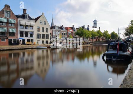 Reflets de maisons traditionnelles, barges et bateaux sur le petit canal (klein Diep) à Dokkum, Frise, pays-Bas, avec le Oud Stadhuis Banque D'Images