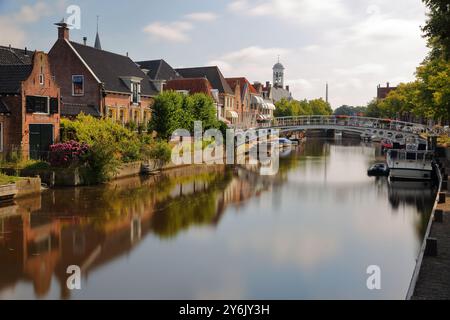 Reflets de maisons traditionnelles, barges et bateaux sur le petit canal (klein Diep) à Dokkum, Frise, pays-Bas, avec le Oud Stadhuis Banque D'Images