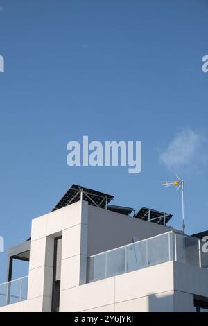 Détail du toit d'un chalet individuel à l'architecture avant-gardiste. Il a des panneaux solaires photovoltaïques, le ciel est clair et bleu. Durabilité, Banque D'Images