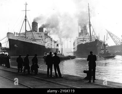 Le géant Cunard White Star Liner de Queen Mary se prépare à l'Ocean Dock à quitter Southampton pour ses essais vers le Firth of Clyde nuages de fumée tourbillonnant de ses entonnoirs indiquant des préparatifs pour le départ et l'ancien navire amiral Berengaria de la flotte Cunard White Star est à destination de l'Amérique le 15 avril 1936 Banque D'Images