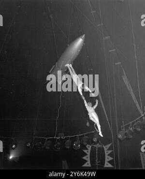 Les Bronleys , interprètes aériens intrépides d'Allemagne , répétant pour leur acte au Bertram Mills Circus à Olympia , Londres . Montant au-dessus de l'anneau de cirque dans une fusée , ils effectuent ensuite quelques exploits de gymnastique étonnants sur des engins suspendus à la fusée alors qu'elle orbite autour de l'arène le 18 décembre 1964 Banque D'Images