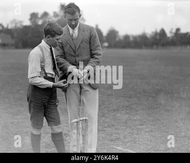 R H Bettington , Capitaine de cricket de l'Université d'Oxford , entraîne les garçons de l'école St Aloysius dans les méthodes correctes du jeu . Montrer à un bowler la bonne façon de tenir la balle pour son style particulier. 5 juin 1923 Banque D'Images