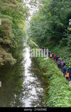 Groupe de personnes sur une promenade de bien-être le long du chemin de halage du canal de Basingstoke par un matin d'automne humide, Surrey, Angleterre, Royaume-Uni Banque D'Images