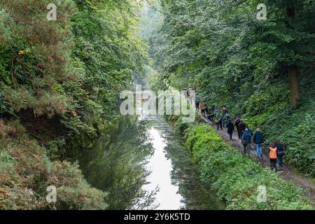 Groupe de personnes sur une promenade de bien-être le long du chemin de halage du canal de Basingstoke par un matin d'automne humide, Surrey, Angleterre, Royaume-Uni Banque D'Images