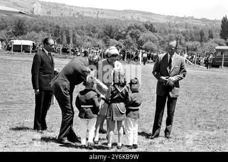 Pucon, Chili : trois enfants locaux (deux garçons et une fille), s'habillant en mascottes de la brigade des pompiers, présentent la reine Elizabeth II avec un bouquet ici le 15 novembre. Prenant le bouquet des enfants est le ministre des Affaires étrangères Valdes. La reine accompagnée du prince Philip (à l'extrême droite) est en visite d'Etat de 8 jours au Chili. 19 novembre 1968 Banque D'Images