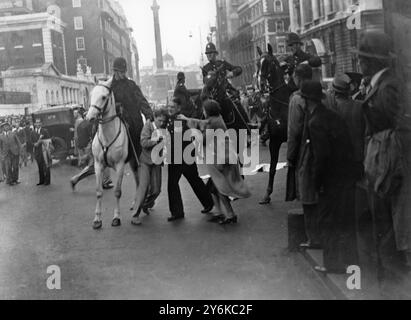 Après la manifestation de paix à Trafalgar Square , des émeutes ont éclaté à Whitehall lorsque des membres de la foule ont essayé de briser le cordon de police à Downing Street. La police montée et pédestre a chargé la foule à plusieurs reprises. Photo montre : un policier luttant avec un émeutier arrêté à Whitehall alors qu'une fille attemps un sauvetage. Deux officiers montés se joignent et celui de gauche a l'homme en difficulté par le col. 8 septembre 1938 Banque D'Images