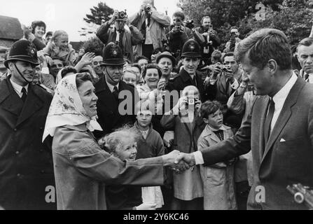 Forest Row, Sussex : Une femme au foyer locale serre la main du président américain John Kennedy alors qu'il quitte la chapelle de notre-Dame de la forêt où il assistait à la messe du matin. Le président a conduit à la chapelle de Birch Grove où il a des entretiens avec le premier ministre Harold Macmillan . Femme est catholique femme au foyer Colette et sa fille est la petite blonde (Caroline Hardy). 30 juin 1963 Banque D'Images