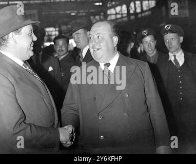 À Waterloo Station - Charles Laughton (1er juillet 1899-15 décembre 1962) acteur de scène et de cinéma anglais, scénariste, producteur et réalisateur. Et - Alfred Hitchcook - Sir Alfred Joseph Hitchcock, KBE (13 août 1899 - 29 avril 1980) était un réalisateur et producteur américain d'origine anglaise emblématique et très influent qui a été le pionnier de nombreuses techniques dans les genres suspense et thriller. 18 juillet 1938 © TopFoto Banque D'Images