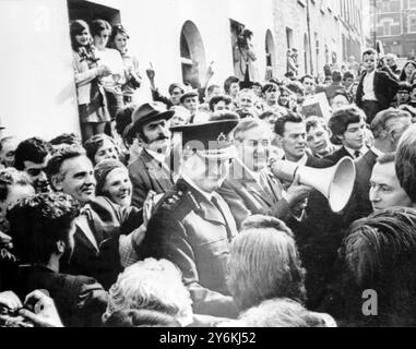 Belfast, Irlande du Nord : le ministre britannique de l'intérieur, M. James Callaghan, (au centre, tenant le loudhailer), est accueilli par une grande foule de résidents locaux, alors qu'il effectue une visite ici le 11 octobre, dans le quartier de Bogside de la ville. L'homme en uniforme est Sir Arthur Young, le nouvel inspecteur général de l'Ulster, qui a présenté Callaghan à la foule. La nuit dernière, trois personnes ont été tuées, et au moins 43 blessées, lors d'une "nuit de terreur", suite à l'affrontement entre 200 soldats et 2 000 personnes qui protestaient contre la proposition de dissoudre les B-Specials. M. Callaghan, qui est en visite le week-end dans le Nord Banque D'Images