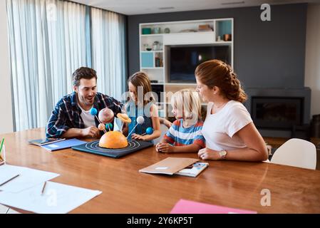 Parents, enfants et projet scientifique pour l'école à la maison, la construction du système solaire et la créativité. Famille, enfants de soutien et affectation élémentaire sur Banque D'Images