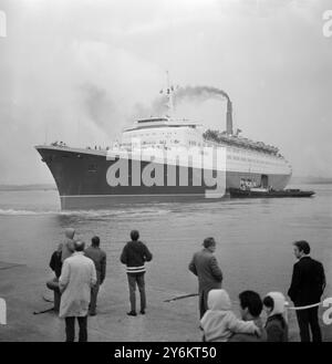 Southampton, Angleterre : quittant Southampton Water de l'Ocean Dock à 19 heures le majestueux paquebot Queen Elizabeth II, surveillé par une petite foule de spectateurs, le navire de 30 millions de livres sterling est en traînée dans le chenal le navire n'a pas déménagé du terminal Ocean de Southampton depuis qu'il est entré au port le 2 janvier avec de graves dommages aux deux rotors du moteur. Hier, les moteurs du paquebot ont été testés avec le navire solidement arrimé au quai du terminal Ocean. Tout s'est bien passé et les constructeurs navals Upper Clyde, qui ont construit le paquebot ont décidé aujourd'hui d'avancer le temps de navigation de 7,30 demain matin à ce e Banque D'Images