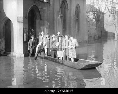 Wedding Row. Parce que la place entourant l'église St Mary de Lode, Gloucester a été inondée, par endroits, à une profondeur de quatre pieds, une fête nuptiale a dû ramer dans l'eau après un mariage l'hier. La mariée Mlle Joan Bayley, et le marié M. William Deans, ont dû être transportés à l'église avant la cérémonie car aucun bateau n'a pu être trouvé le 21 mars 1947 Banque D'Images