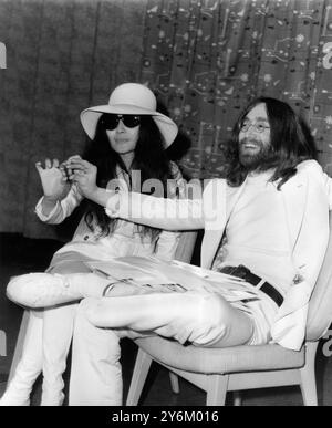 Glands pour la paix Beatle John Lennon et sa femme Yoko, après leur arrivée à l'aéroport de Londres (Heathrow) le 1er avril 1969. Ils étaient restés au lit pendant une semaine à l'hôtel Hilton Amsterdam, pour protester contre la violence dans le monde. Ils tiennent chacun un petit gland, qu'ils ont annoncé qu'ils envoyaient à chacun des dirigeants du monde, pour leur demander de les planter pour la paix. Banque D'Images