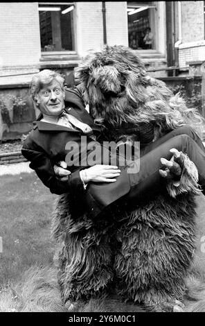 Londres : Jon Pertwee met un visage courageux alors qu'il est tenu dans les bras d'un 'Yeti', l'un des personnages bizarres de la nouvelle série Dr Who, qui revient sur les écrans de télévision de la BBC en janvier prochain. Jon Pertwee, sera le nouveau Dr Who, qui sera vu en couleur pour la première fois. Juin 1969 Banque D'Images