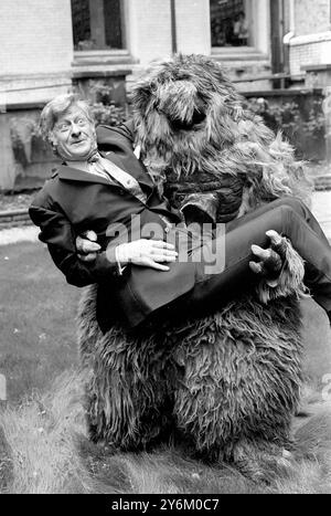 Londres : Jon Pertwee met un visage courageux alors qu'il est tenu dans les bras d'un 'Yeti', l'un des personnages bizarres de la nouvelle série Dr Who, qui revient sur les écrans de télévision de la BBC en janvier prochain. Jon Pertwee, sera le nouveau Dr Who, qui sera vu en couleur pour la première fois. Juin 1969 Banque D'Images