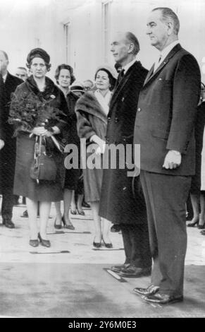 Washington, DC USA : rivalisant avec les artistes du Merseyside, 'les Beatles', pour l'affection des Américains à Washington, sont le premier ministre britannique, Sir Alec Douglas-Home (au centre) et son épouse, bouquet Holding, Lady Douglas-Home (à gauche) qui sont photographiés avec leurs hôtes, le président américain, M. Lyndon B. Johnson (à droite) et Mme Claudia 'Lady Bird' Johnson (au centre, vêtue d'un manteau de fourrure) lors des cérémonies de la Maison Blanche, aujourd'hui. 12 février 1964 Banque D'Images