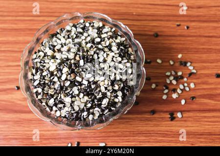 Split Black Lentil également connu sous le nom de Black Gram, Black urad Dal, Vigna Mungo, urad Bean sur fond de bois brun Banque D'Images