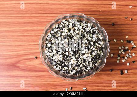 Split Black Lentil également connu sous le nom de Black Gram, Black urad Dal, Vigna Mungo, urad Bean sur fond de bois brun Banque D'Images