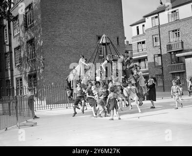 Enfants jouant dans une aire de jeux du centre-ville. Super fun. Probablement publié le 20 juillet 1938 City Playground - rond-point Banque D'Images