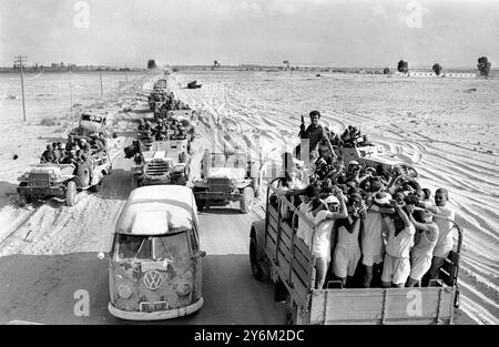 Guerre des 6 jours El Arish, Egypte : les prisonniers égyptiens, les mains au-dessus de la tête, sont transportés au camp, tandis qu'une colonne blindée israélienne se déplace dans la direction opposée près d'ici ce matin. 8 juin 1967 Banque D'Images