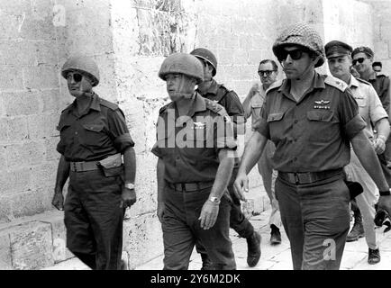 Jérusalem, Jordanie : le général Moshe Dayan (à gauche), ministre israélien de la Défense, avec le général Yitzhak Rabin (au centre), chef d'état-major israélien, et le commandant local (à gauche) en route vers le mur des lamentations après que les troupes et les chars israéliens aient achevé l'occupation de la moitié jordanienne de Jérusalem hier. Des milliers de juifs exultants ont couru en procession triomphale vers le mur et, pour la première fois en 20 ans, ont prié dans le sanctuaire historique. Dans l'ombre du mur des lamentations, le général Dayan a déclaré : « nous tendons sincèrement nos mains à nos frères arabes en paix, mais nous n'avons jamais rendu Jérusalem par nos mains Banque D'Images