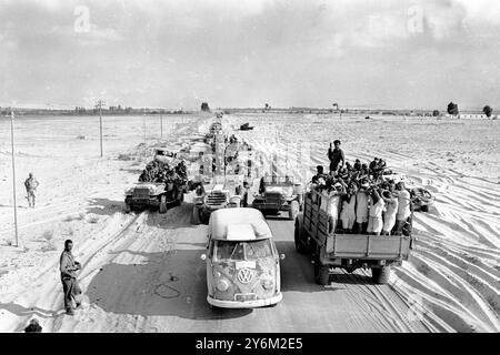 Guerre des 6 jours El Arish, Egypte : les prisonniers égyptiens, les mains au-dessus de la tête, sont transportés au camp, tandis qu'une colonne blindée israélienne se déplace dans la direction opposée près d'ici ce matin. 8 juin 1967 Banque D'Images