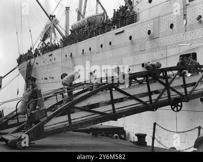 3 septembre 1947 les troupes britanniques arrivent en Inde. Environ 1 000 hommes de l'armée britannique se retirant du nouveau Dominion d'Inde, et quelque 250 familles de militaires arrivent à Liverpool à bord du navire de troupes Georgic en provenance de Bombay. La plupart des hommes du Royal Norfolk Regiment stationnés au Pendjab depuis 1940 ont été la première unité britannique à être officiellement évacuée. Heureux d'être à nouveau à la maison, certains soldats débarquent rapidement du navire de troupes Georgic en arrivant à Liverpool depuis Bombay Banque D'Images