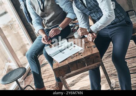 En passant en revue les détails. Gros plan vue de dessus de deux hommes choisissant le design tout en passant du temps dans l'atelier Banque D'Images