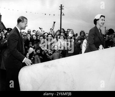 La reine et le duc d'Édimbourg sourient en réponse à la foule ravie qui les encourage alors qu'ils montent à bord du yacht royal Britannia à Barrow-in-Furness. Le couple royal, qui avait fait une excursion d'une journée dans le Westmorland, partait pour une croisière de vacances dans les îles occidentales d'Écosse. Attendant dans la Britannia pour les accueillir étaient leurs enfants le Prince Charles et la Princesse Anne - qui avaient navigué de Southampton - et la Princesse Margaret, qui avait volé à Barrow de Londres. - 11 août 1956. ©2006 TopFoto Banque D'Images