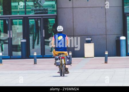 France, ile-de-France, Paris, facteur, par derrière sur un vélo devant un immeuble avec l'inscription hauts-de-Seine, le département Banque D'Images