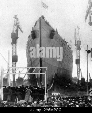 Après que la princesse Mary (sur la plate-forme au premier plan à gauche) avait cassé sur ses arcs une bouteille de vin de Dominion : H.M.S. 'Rodney' prenant l'eau à Birkenhead. 26 décembre 1925 Banque D'Images