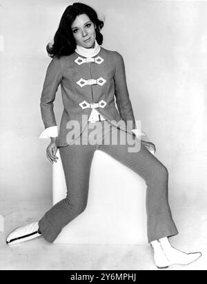 Londres : Diana Rigg porte le 'V.I.P., le costume-pantalon natty en laine de moutarde de 'Jean Varon conçu par John Bates pour sa garde-robe 'Emma Peel' dans la langue de la télévision A.B.C. dans le thriller de joue 'The Avengers'. Le quatrième et dernier épisode de 26 du thriller revient au P.V.C. fait également la ceinture. Il y a un chemisier blanc en crêpe et l'ensemble est vendu par Reginald Bernstein pour 30 !/' guinées. Ce costume ne sera pas vu dans 'The Avengers' avant le nouvel an. 27 septembre 1965 Banque D'Images