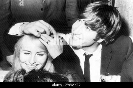 New York, États-Unis : The British Pop Group - 'les Beatles sont actuellement en visite aux États-Unis, et John Lennon est le seul homme marié parmi eux, est montré avec sa femme blonde, Cynthia (22 ans) au Pepper Mint Lounge Twist Haven ici tard hier. Lennon montre à la société l'alliance sur le doigt de sa femme. Le couple qui s'est rencontré au Liverpool College of Art il y a environ six ans a un fils Bay de neuf mois. 10 février 1964 Banque D'Images