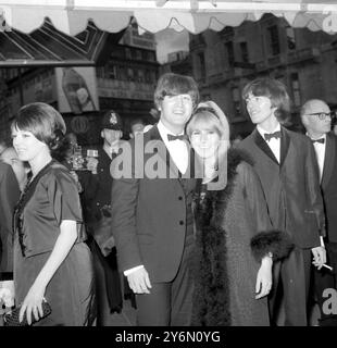 Londres : Beatle John Lennon embrasse sa femme Cynthia, devant le pavillon de Londres ici hier soir à la première mondiale royale de leur dernier film, 'Help'. Un heureux et détendu George Harrison surveille la foule qui s'est réunie à l'extérieur du théâtre pour les voir. Environ 10 000 jeunes ont sillonné l'avenue Shaftesbury et le quartier Piccadilly Circus pour voir leurs chanteurs préférés. 29 juillet 1965 Banque D'Images