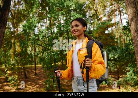 Une jeune femme fait des randonnées à travers une belle forêt d'automne, entourée d'arbres colorés et d'air frais. Banque D'Images