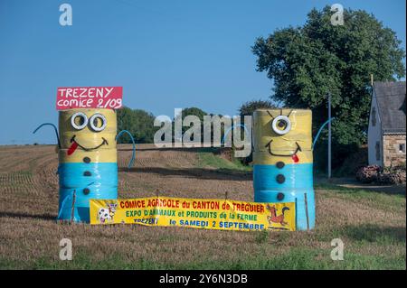 France. Brittany. Côtes d’Armor. Des balles de foin amusantes annonçant un salon agricole dans la région de Treguier Banque D'Images