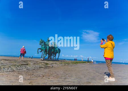 Belgique, région flamande, Flandre occidentale, Nieuport, Nieuwpoort, couple senior sur la plage, prenant photo avec monument. Hommes Banque D'Images