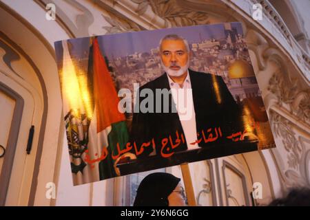 Tunis, Tunisie. 24 septembre 2024. Tunis, Tunisie. 24 septembre 2024. L'image du dirigeant du Hamas récemment assassiné, Ismail Haniyeh, est soulevée lors d'une manifestation devant le théâtre municipal de Tunis. Les participants ont agité le drapeau palestinien, libanais et Hezbollah, en solidarité avec les Palestiniens et le peuple libanais et pour condamner les frappes aériennes israéliennes au Liban et à Gaza. L'offensive militaire israélienne dans la bande de Gaza s'est poursuivie depuis l'attaque du Hamas le 7 octobre 2023 ; l'armée israélienne a également mené d'intenses frappes aériennes au Liban depuis début lundi 23 septembre, Banque D'Images