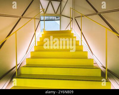 Regardant vers le haut un escalier jaune vif moderne vide menant vers le haut vue d'en bas dans un immeuble de bureaux. Design architectural contemporain. Escaliers à l'intérieur Banque D'Images