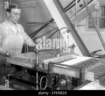 Fabrication de briques de glace à Cadby Hall. Couper la glace en blocs par une série de scies circulaires. 1922 Banque D'Images