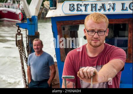 Shane Ball, 24 ans, skipper le bateau de pêche familial hors du port de Rye, comme son père Robert (59 ans) le regarde avec fierté, août 2017. Shane et Robert sont en mer pendant plus de 12 heures, capturant principalement la sole de Douvres, la plie, les fouets et les dabs. Banque D'Images